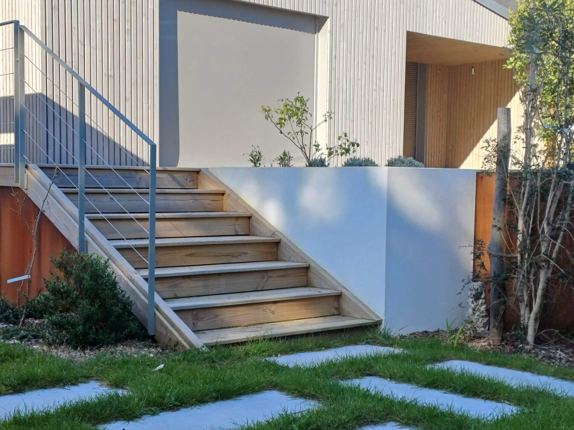 Un escalier en bois menant à une maison blanche