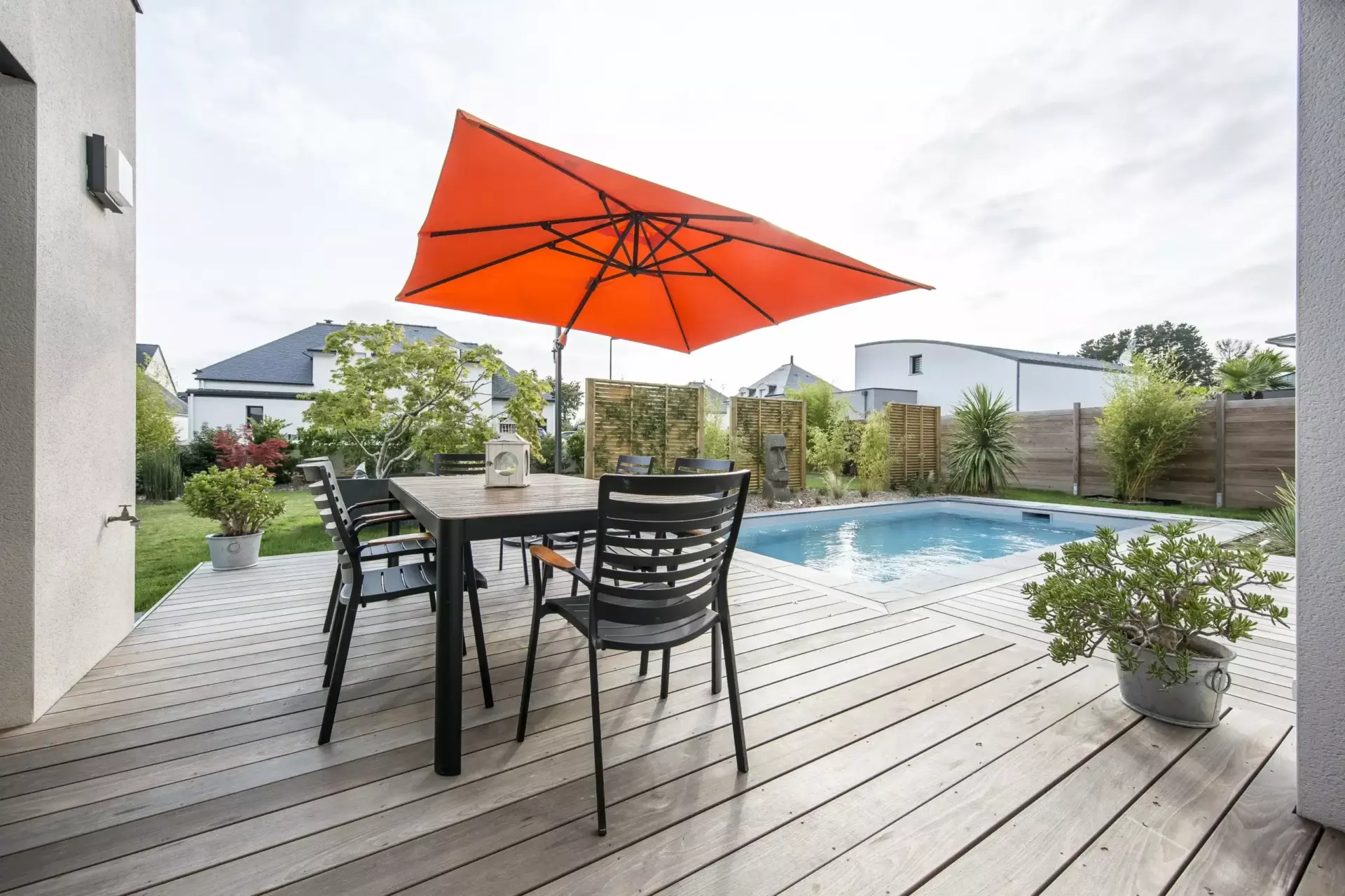 Un patio avec une table, des chaises et un parasol.