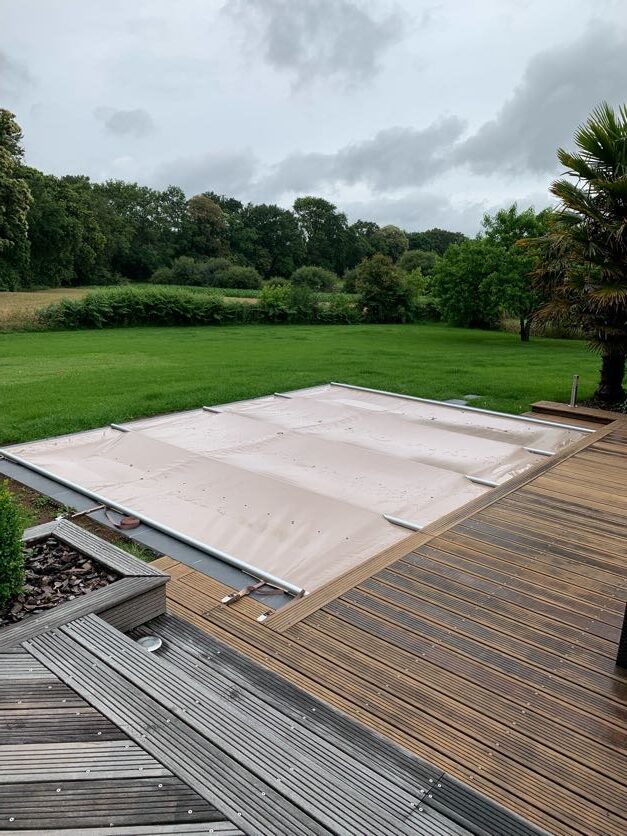 Bâche à barres couvrant une piscine, solution classique pour sécuriser et protéger le bassin